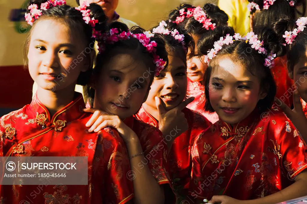 Thailand, Bangkok, High School girls in Chinese Cheong sam dress in parade celebrating local temple.