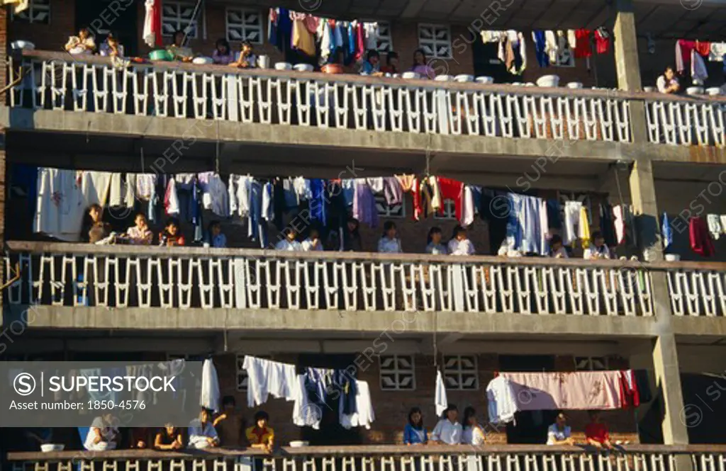China, Yunan Province, Jinghong, Laundry Hanging On Apartment Balconies In The Xishuangbana Area With Residents Looking Down On Street.
