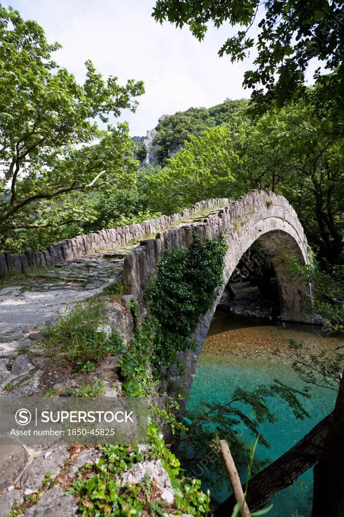 Greece, Ioannina, Zagorohoria, Voidomatis, Old Greek traditional arch style stone bridge at a nature protected area with the cleanest rivers in Europe.