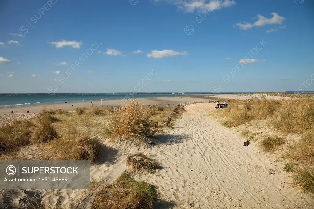 England, West Sussex, West Wittering Beach, View across sand dunes towards beach and sea at East Head. Sunshine and blue sky.