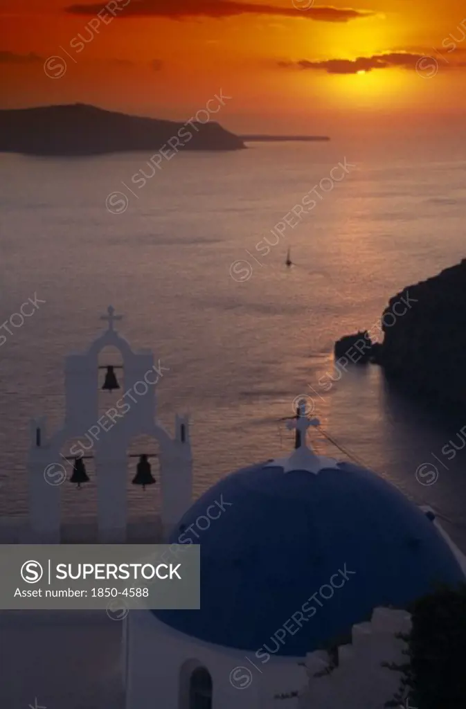 Greece, Santorini, Thira Church, View Across The Water At Sunset From Above The Blue And White Church Domes And Bell Tower