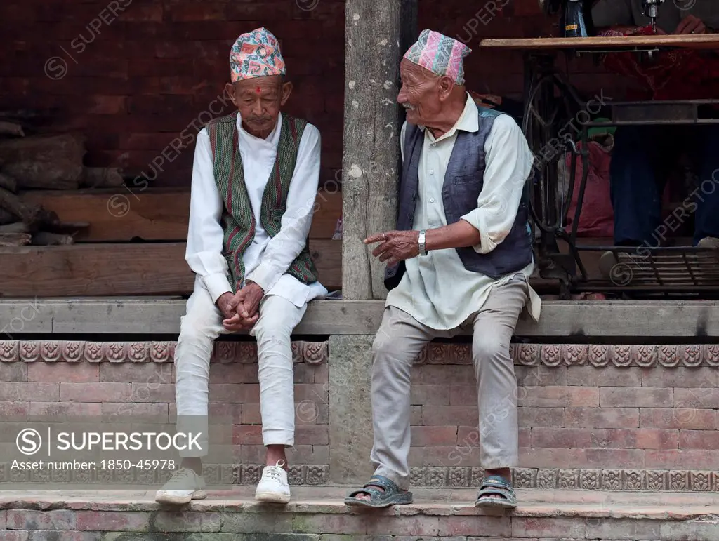 Nepal, Kathmandu, Two older men in national clothes are talking.
