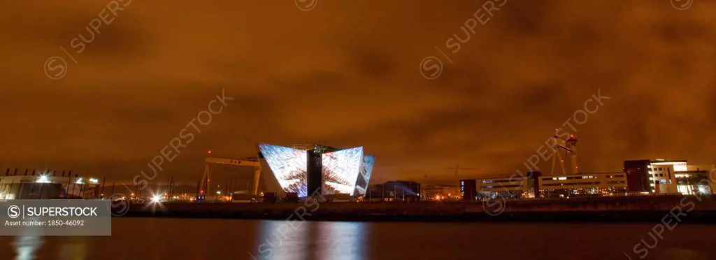 Ireland, North, Belfast, Titanic Quarter, Visitor centre designed by Civic Arts & Eric R Kuhne, illuminated at night.