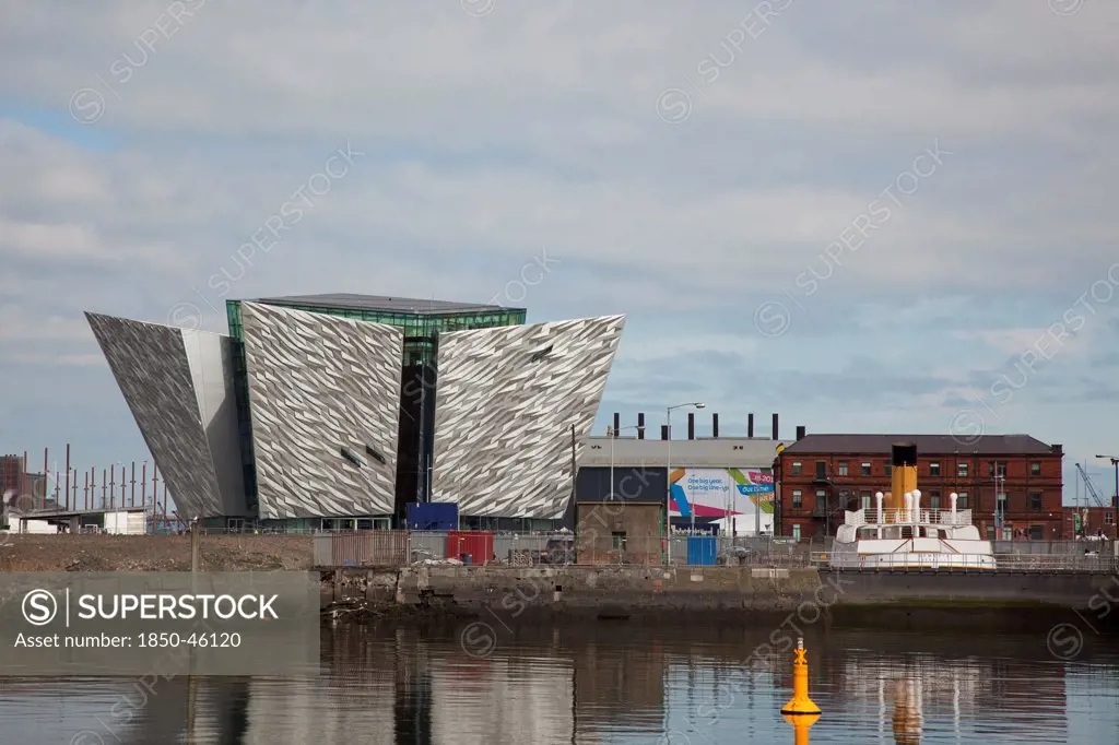 Ireland, North, Belfast, Titanic Quarter, Visitor centre designed by Civic Arts & Eric R Kuhne, with the launch SS Nomadic in the foreground.