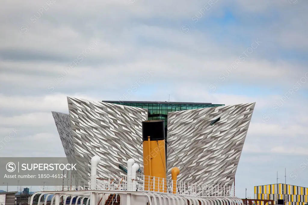 Ireland, North, Belfast, Titanic Quarter, Visitor centre designed by Civic Arts & Eric R Kuhne, with funnel of SS Nomadic in the foreground.