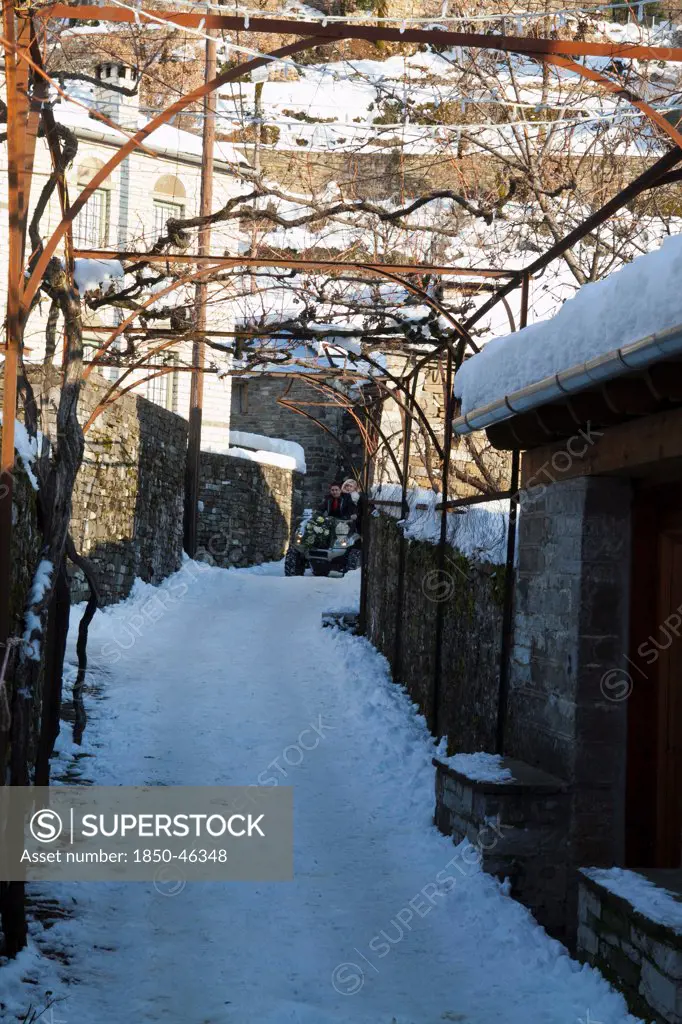 Greece, Macedonia, Zagorohoria, Little Papigko Village, Narrow and frozen alley at the end of which a four weel drive bugy is noticeable, at the well known Mikro Papigko.