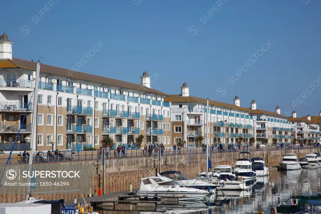 England, East Sussex, Brighton, view over boats moored in the Marina with apartment buildings behind.