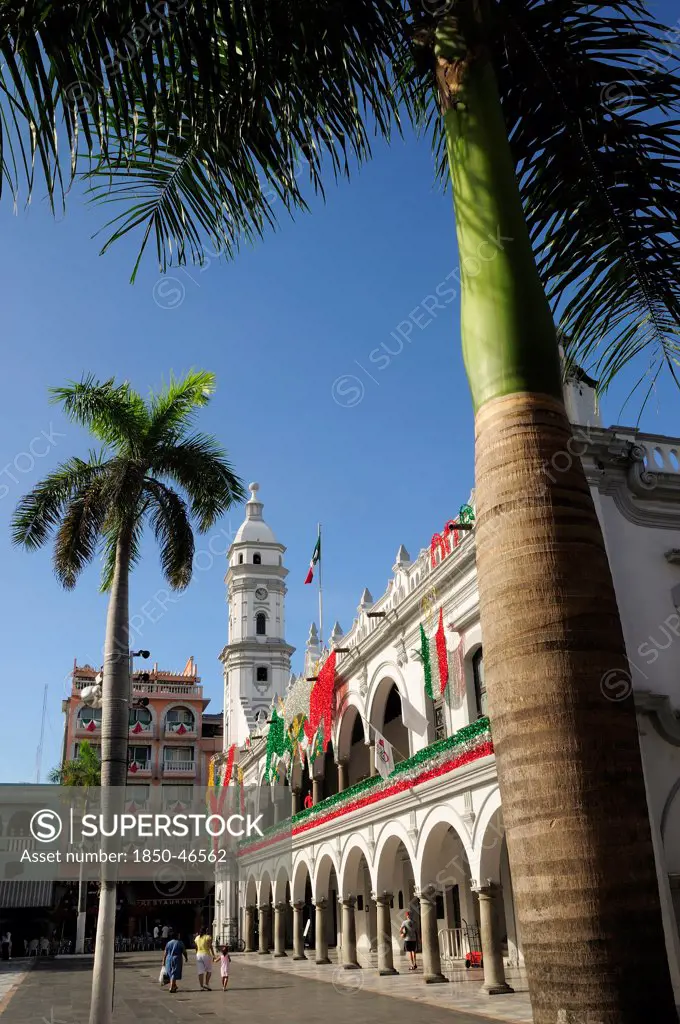 Mexico, Veracruz, Palm trees in the zocalo and government buildings decorated with national colours.