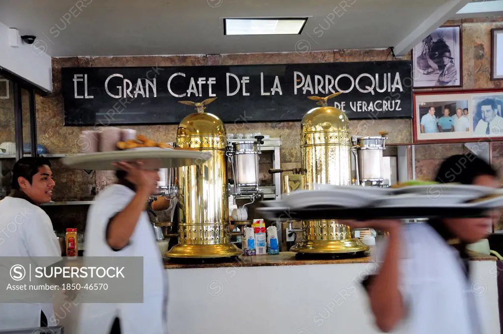 Mexico, Veracruz, Cafe El Gran Cafe de la Parroquia interior with waiters carrying laden trays past bar area.