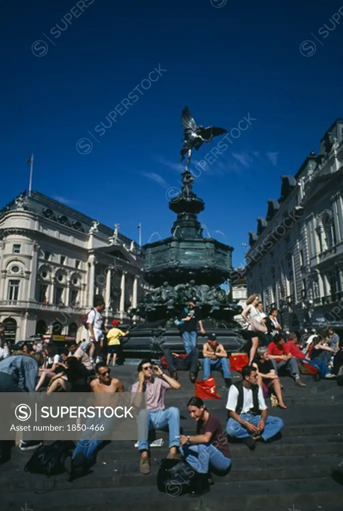 England, London, Picadilly Circus With People Congregating On The Steps Surrounding The Base Of Alfred Gilberts Eros Statue Dating From 1892