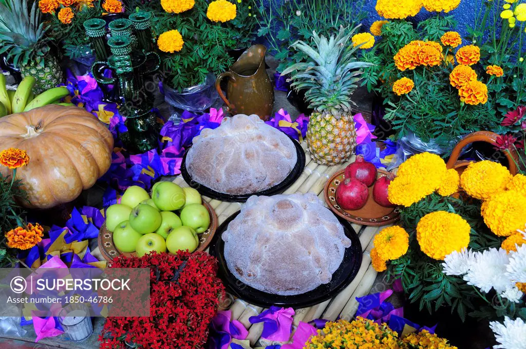 Mexico, Michoacan, Patzcuaro, Altar with display of food and flowers including marigolds for Dia de los Muertos or Day of the Dead festivities.
