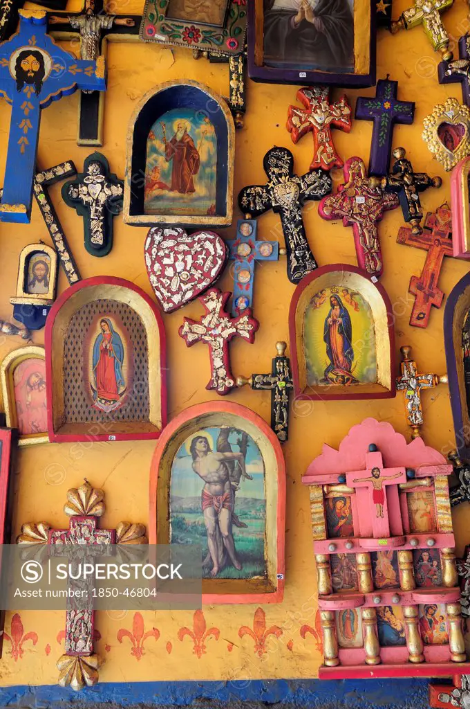 Mexico, Michoacan, Patzcuaro, Religious kitsch art displayed on yellow painted wall.