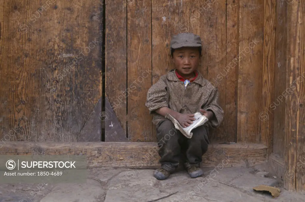 China, Gansu, Xiahe, Young Tibetan Boy Reading A Book