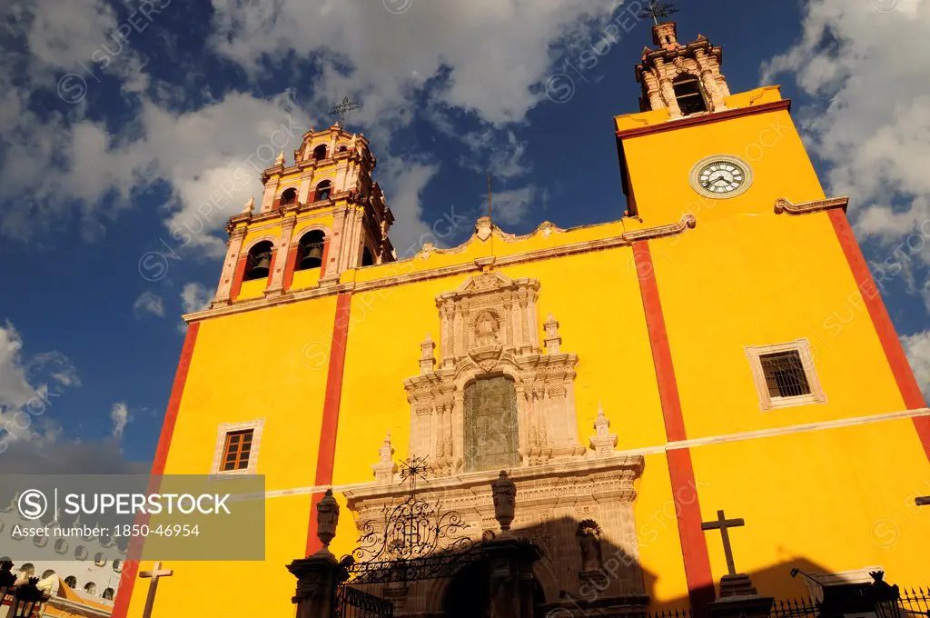 Mexico, Bajio, Guanajuato, Basilica de Nuestra Senora de Guanajuato or Basilica of Our Lady of Guanajuato. Baroque yellow painted exterior facade with clock and bell tower.