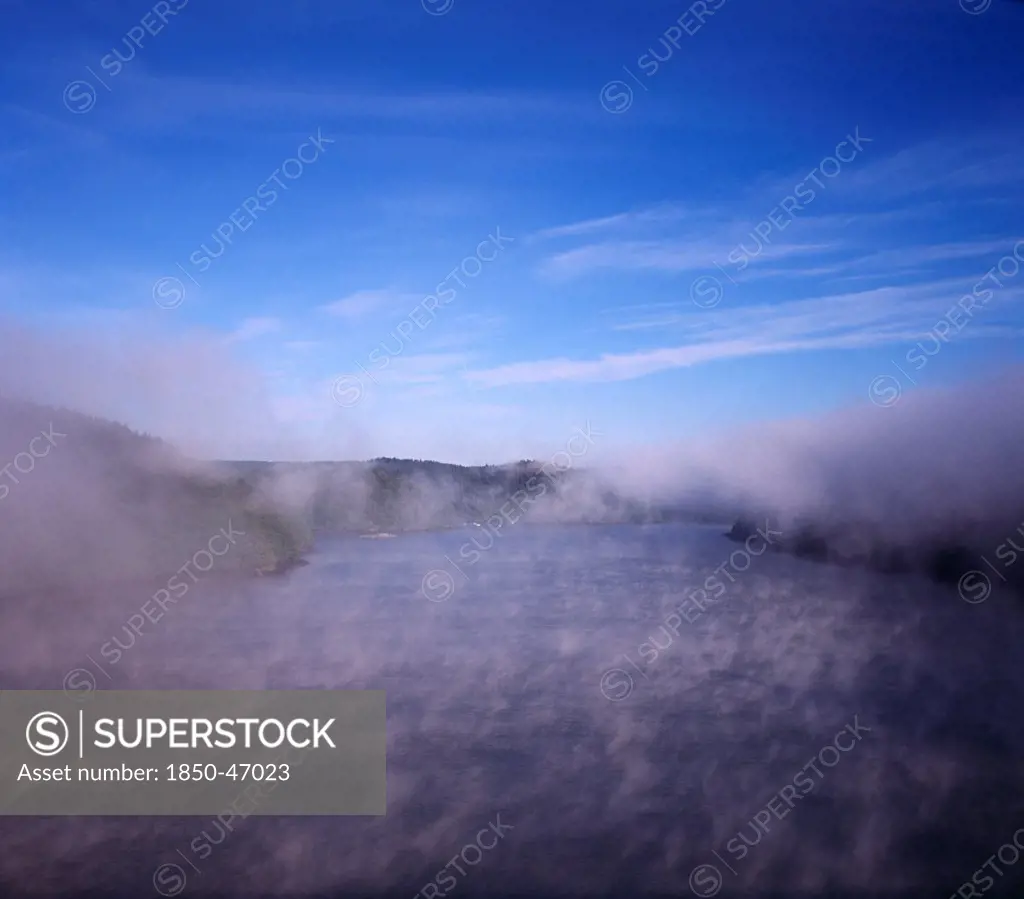 France, Bretagne, River Aulne, View from Pont de Terenez bridge looking west along River Aulne in dawn fog.