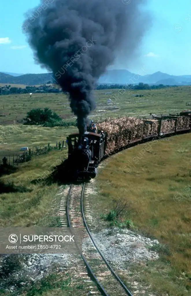 Cuba,  , Holguin, Train Transporting Sugar Cane With Plumes Of Black Smoke Pouring From The Engine