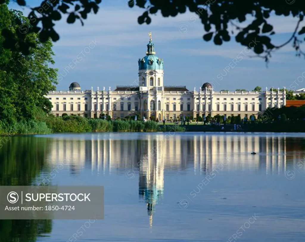 Germany, Berlin, Charlottenburg Palace And Reflection In Lake In The Foreground.  Part Framed By Trees.