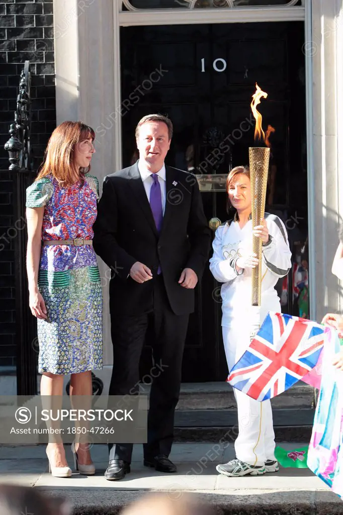 England, London, Olympic Torch relay in Downing Street Samantha and Prime Minister David Cameron welcome the torch.