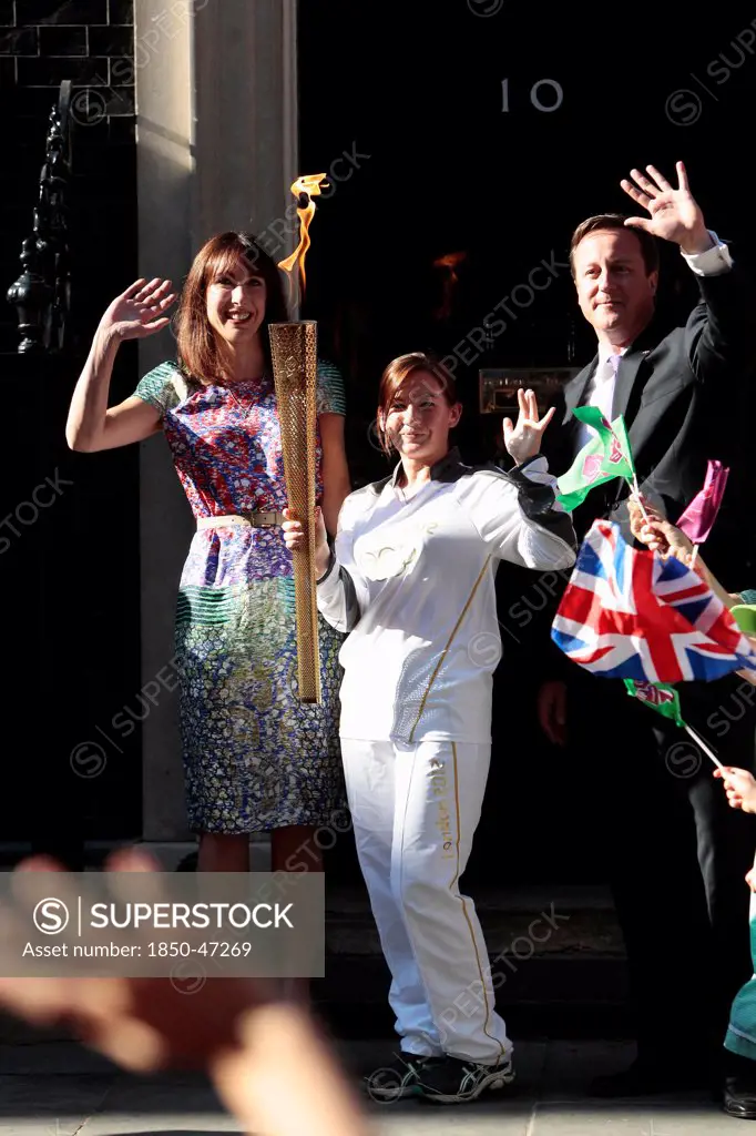England, London, Olympic Torch relay in Downing Street Samantha and Prime Minister David Cameron welcome the torch.