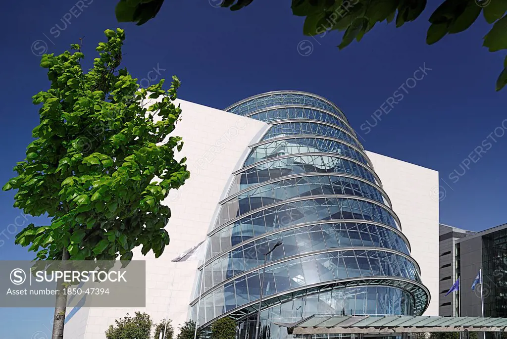 Ireland, County Dublin, Dublin City, Convention Centre building view of the facade with tree in foreground.