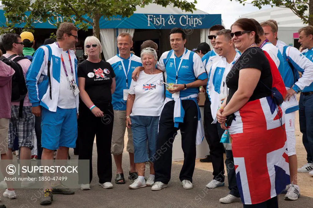 England, London, Stratford Olympic Park Group of Team GB supporters having their photographs taken with competitors from Finland.