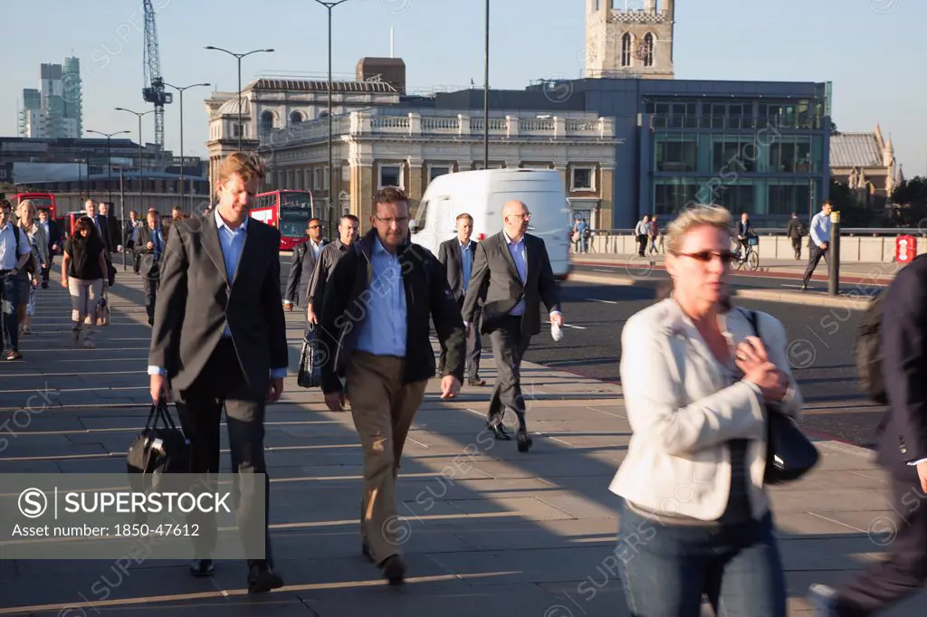 England, London, Early morning commuters crossing London Bridge towards the City Financial district.