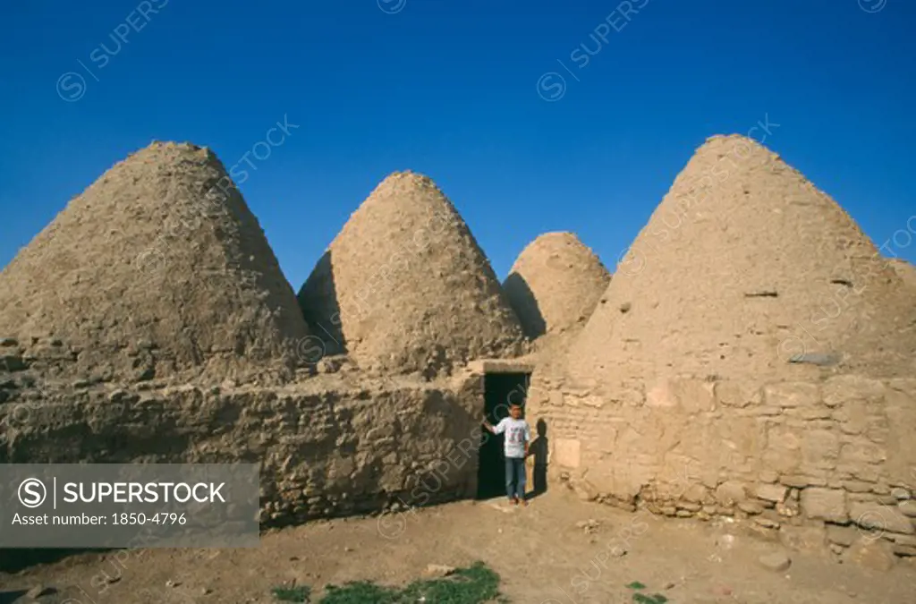 Turkey, Urfa, Harran  , Beehive Mud Houses With Boy Standing At Doorway