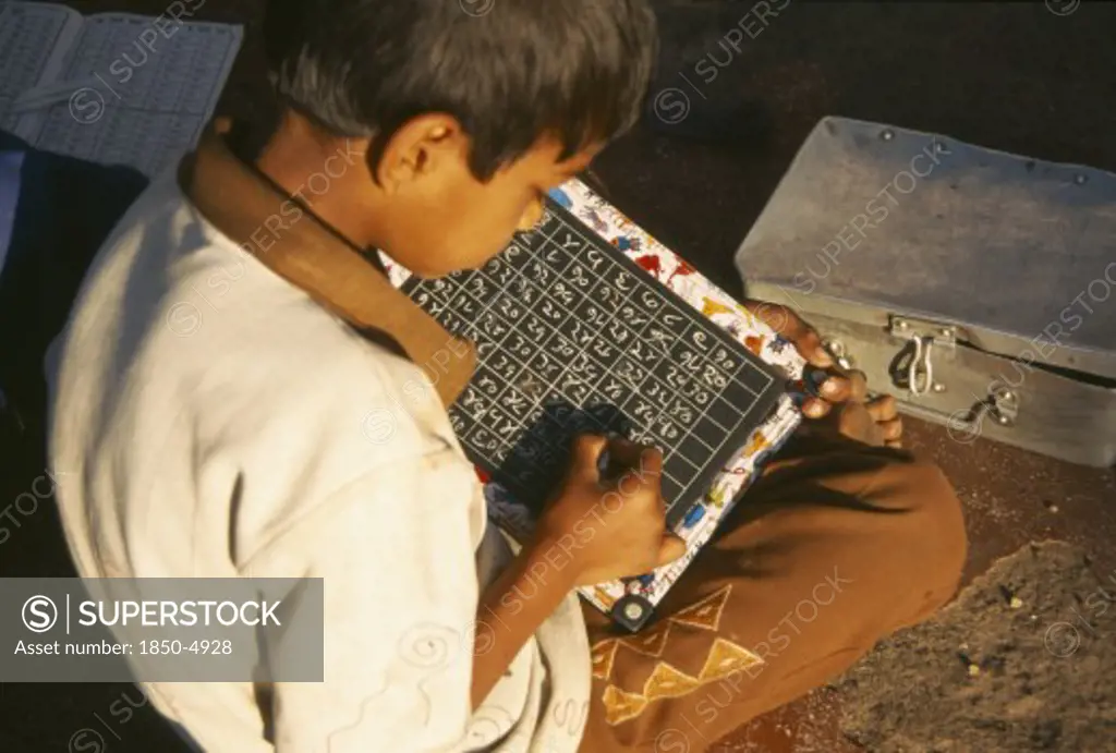 India, Maharashtra, Nasik, School Boy Using Chalk And Slate