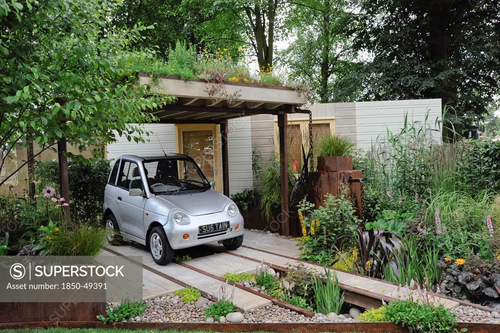 Hampton Court Flowershow 2009 'Rain Chain' garden designed by Wendy Allen incorporating parking for G-Wiz electric car under ÔlivingÕ roof, rain garden and rear wall made from renewable resources.