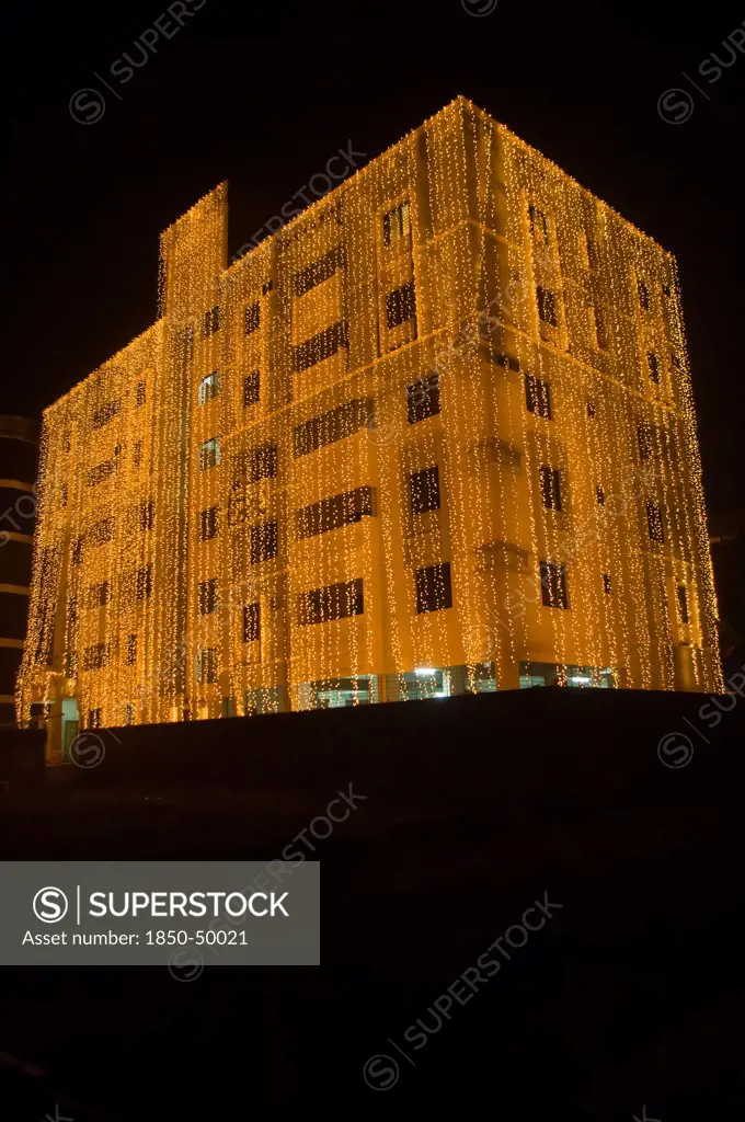 Bangladesh, Dhaka, Gulshan Apartment block at night lit up for a wedding with strings of fairy lights cascading over the side.