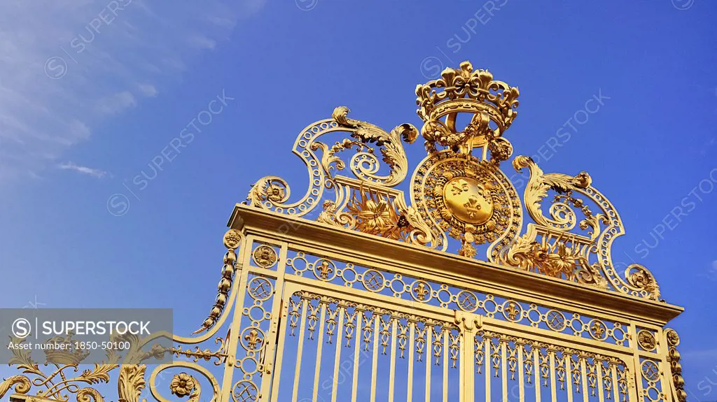 France, Ile de France, Paris, Versailles golden entrance gate against blue sky.