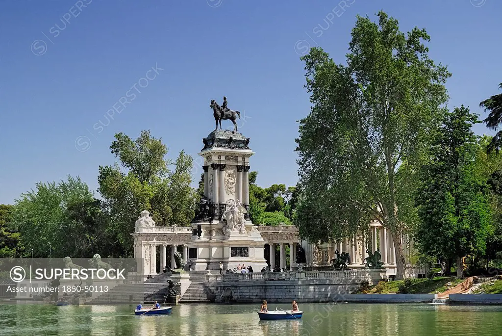 Spain, Madrid, Monument to King Alfonso XII in Parque El Buen Retiro with tourist boating inthe lake.