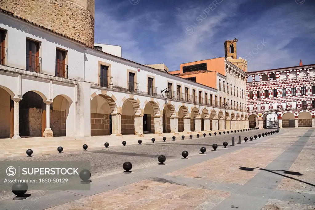 Spain, Extremadura, Badajoz, Colourfully painted buidlings in the Plaza Alta with Espantaperros tower behind.