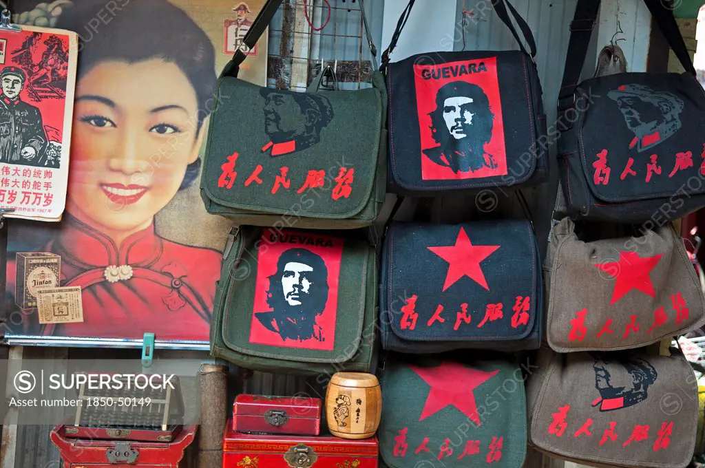 China, Shanghai, Revolutionary kitsch on sale at at Dongtai antique market Chairman Mao Zedong and Che Guevara and Red Star shoulder bags Chinese characters read Serve the People Lin Biao calendar atop Shanghai Belle advertizing poster Fake antique boxes and abacus.
