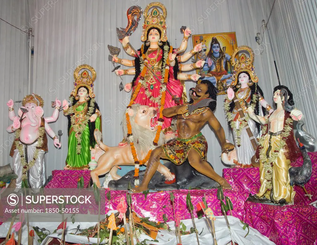 Bangladesh, Dhaka, Durga Puja festival with Durga surrounded by deities and offerings before the altar.