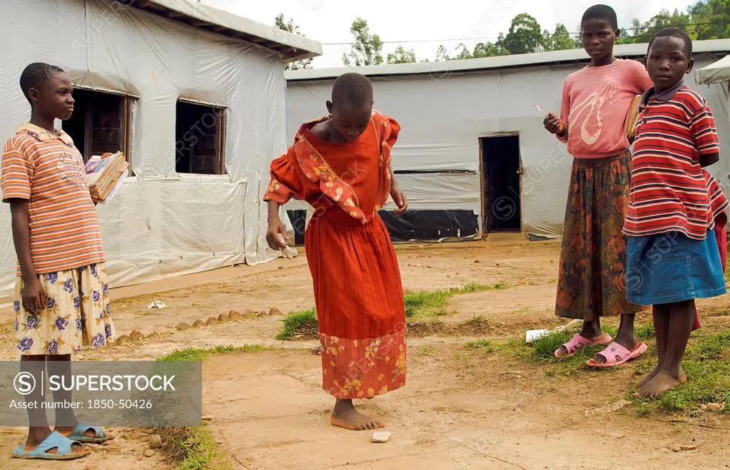 Burundi, Cibitoke Province, Mabayi, Primary School Girls playing hopscotch beside the Catch-up Class for children who have dropped out of school. Concern Worldwide has supported the establishment of a number of classes.