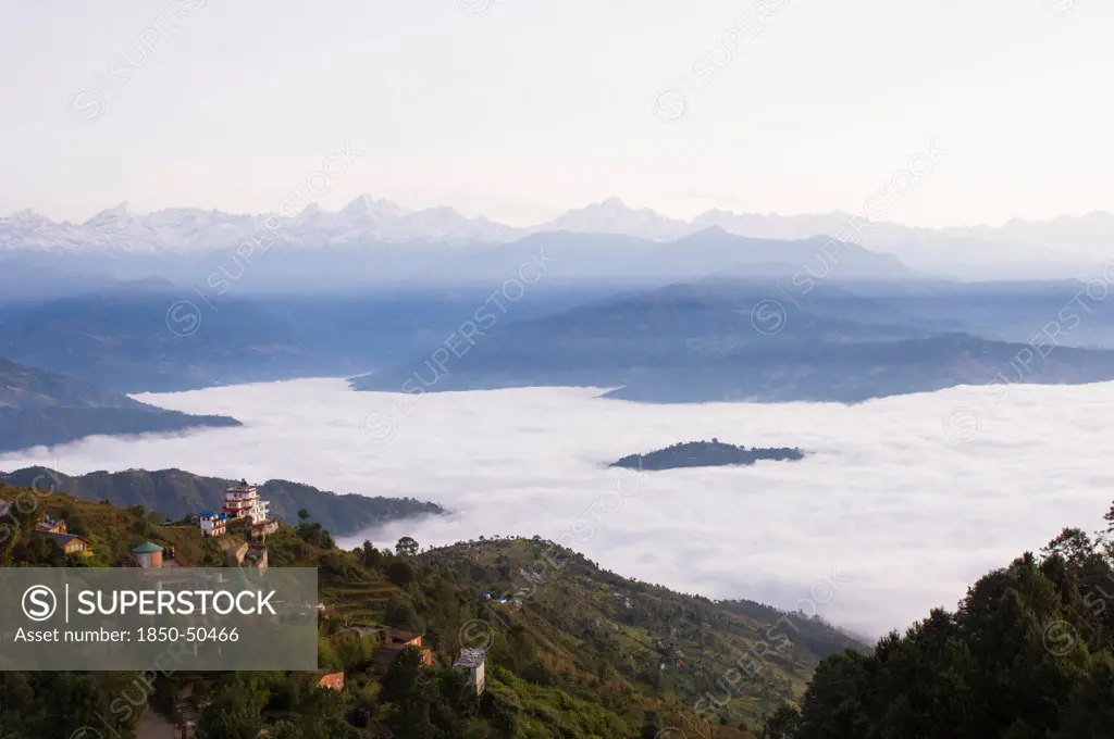 Nepal, Nagarkot, View across clouded valley towards Himalayan mountains.