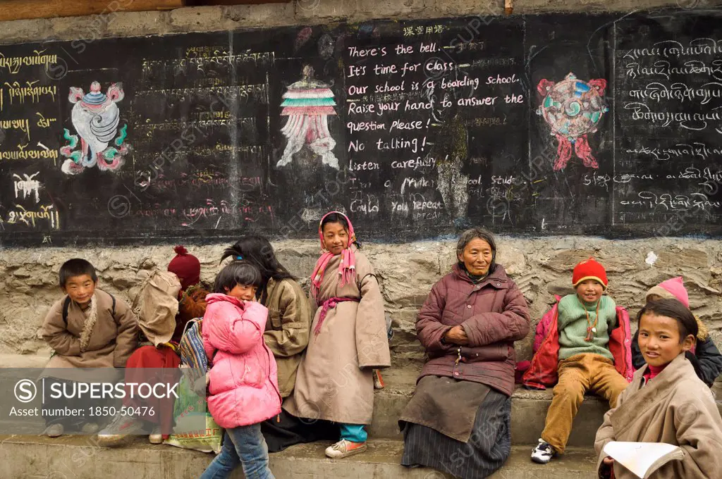 China, Szechuan Province, Tibet, Parents grandparents and children at the entrance to a private boarding school in Tibetan region.