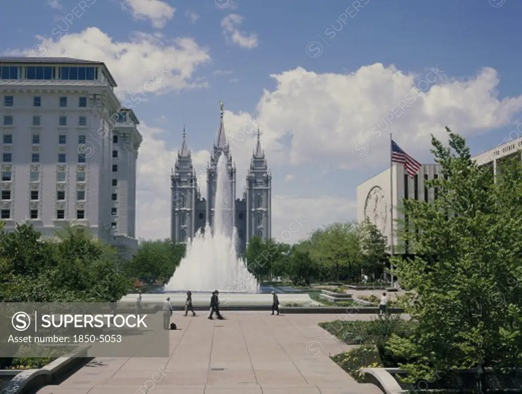 Usa, Utah, Salt Lake City, The Mormon Temple Beyond The Fountain In The Gardens With The Us Flag Flying From A Flagpole