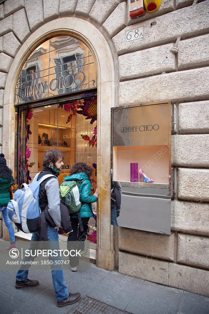 Italy, Lazio, Rome, Via del Condotti Tourists looking at shoe display in the Jimmy Choo shop.