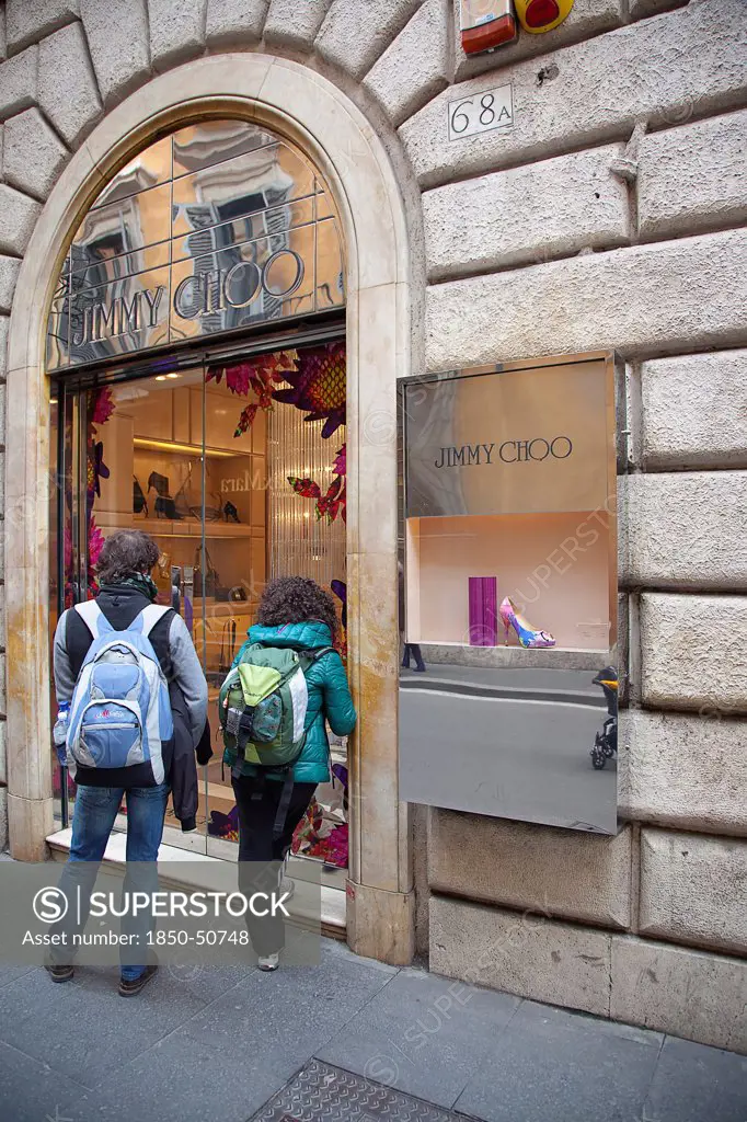 Italy, Lazio, Rome, Via del Condotti Tourists looking at shoe display in the Jimmy Choo shop.