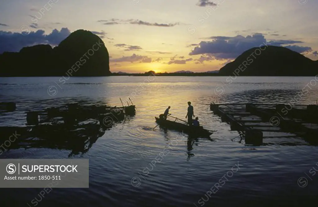 Thailand, Phang Nga, Fish Farm At Sunset With Two Men In A Canoe