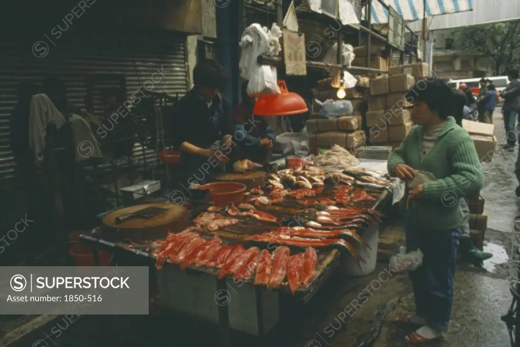 China, Guangdong, Guangzhou, Fish Stall In The Market With Vendor And Customer.