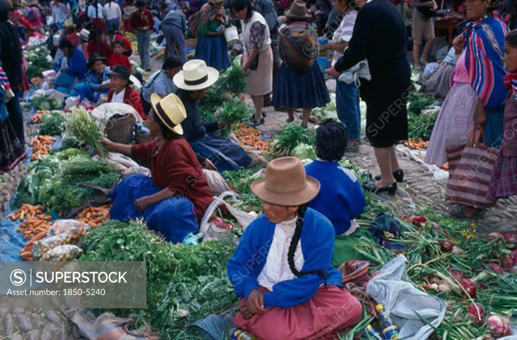 Peru, Cusco Department, Pisac, Vegetable Stalls On The Ground In Cobbled A Market Place. Crowds Of People.