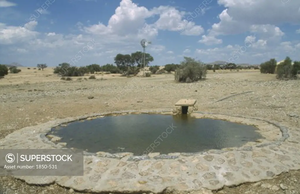 Namibia, Namib Desert, Namib Naukluft Park, Animal Waterhole With Wind Pump In The Distance