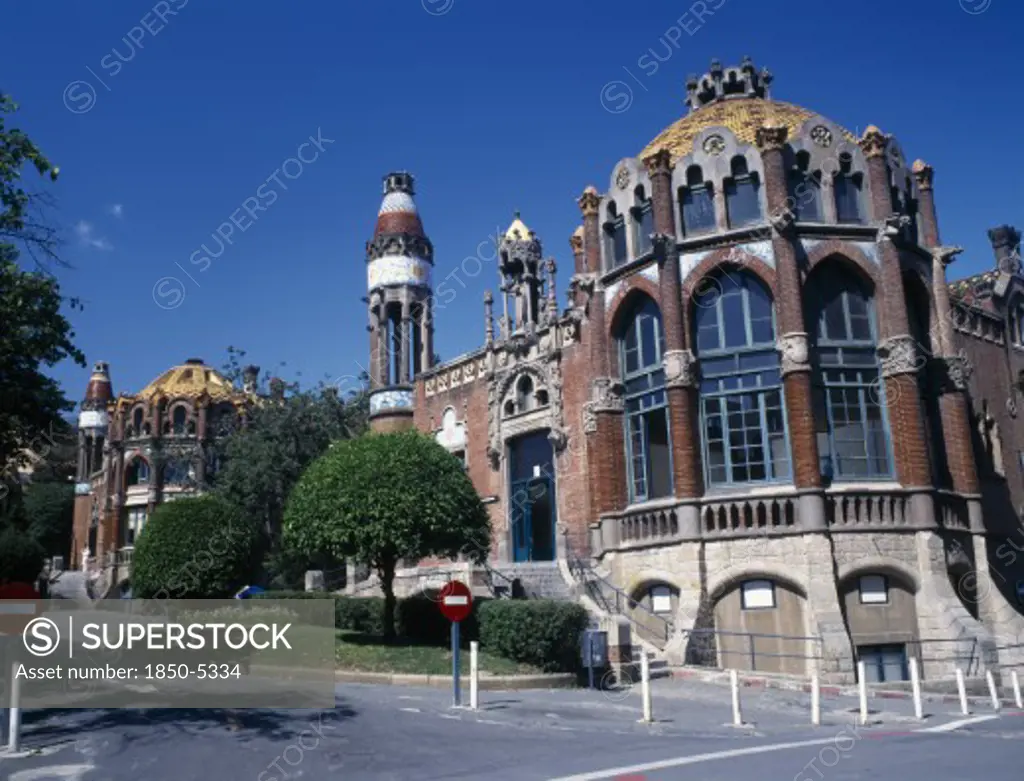 Spain, Catalonia, Barcelona, Hospital De Sant Pau Designed By Domenech I Montaner.  Ornate Facade With Arched Windows And Domed Rooftops.