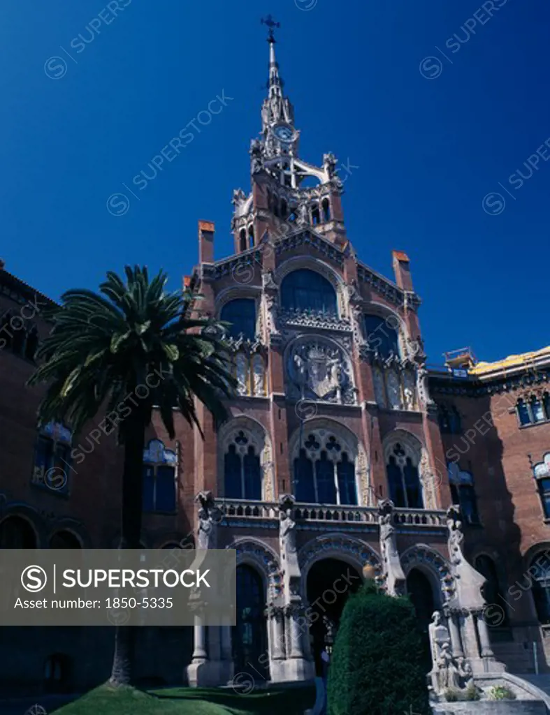 Spain, Catalonia, Barcelona, Hospital De Sant Pau Designed By Domenech I Montaner.  Ornately Carved Entrance With Arched Windows And Clock Tower.