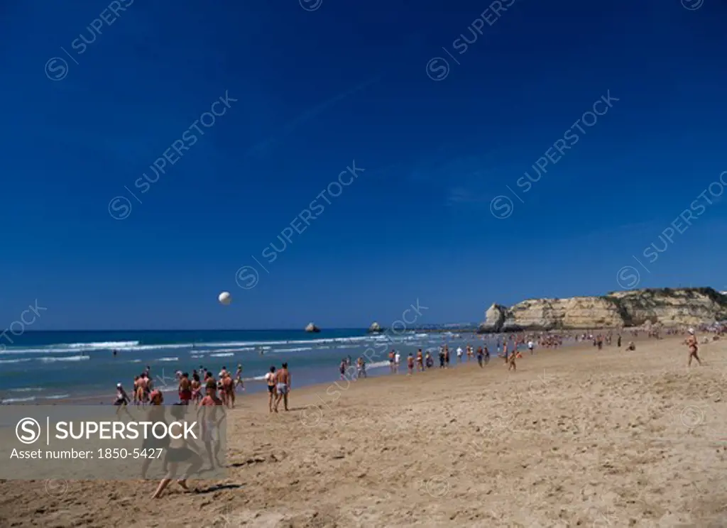 Portugal, Algarve, Praia Da Rocha, View Along Beach With Children Playing Beach Football.