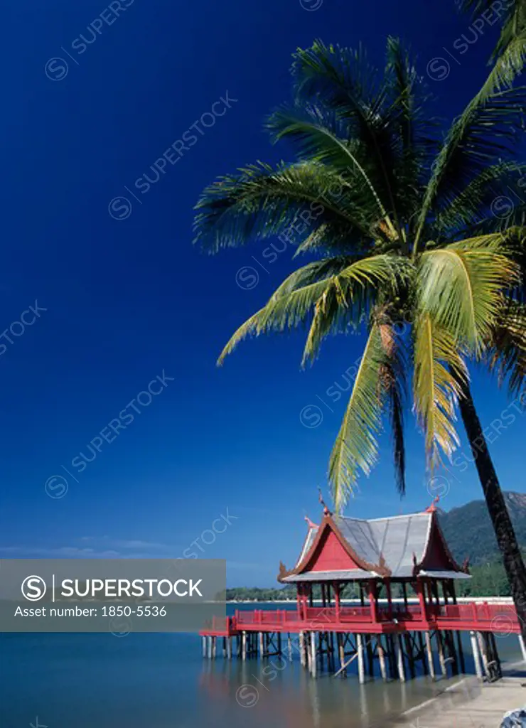 Malaysia, Kedah, Langkawi, Pantai Kok Beach At The Summer Palace With A Coconut Palm Tree Hanging Out Over The Water