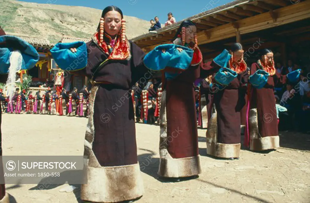 China , Qinghai, Tongren, Line Of Women Dancers In Costume At Tibetan Festival